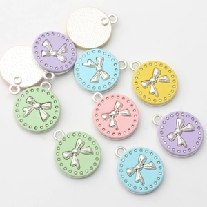 Nahaufnahme bunter runder Schleifenanhänger für DIY-Schmuck mit metallischen Details