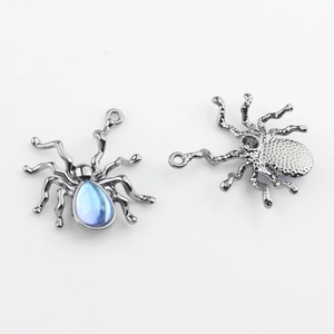 Makro-Detail von Spinnenanhängern aus Legierung mit blauen Steinen und Metallrückseite