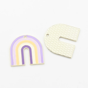 Makro-Detail von U-förmigen Regenbogen-Emaille-Anhängern mit bunter Front und goldener Rückseite