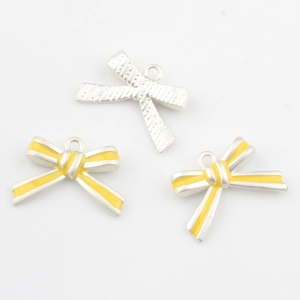 Detailansicht der gelben Emaille- und silbernen Bogenanhänger für DIY-Schmuck