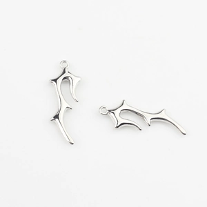 Macro detail of irregular silver-colored thorn pendants for DIY jewelry making