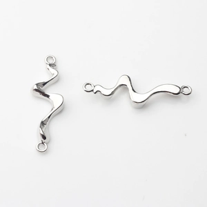 Detail eines polierten silbernen Wellenverbinders mit zwei Ösen für DIY-Schmuck