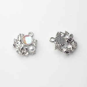 Makro-Detail silberner Blumenanhänger mit irisierenden Steinen und Perlen für DIY-Schmuck