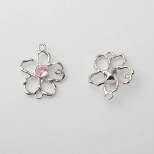 Detailansicht der hohlen Blumenanhänger mit rosa Strasssteinen und silbernem Finish