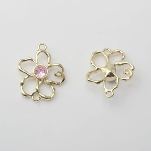 Makroansicht goldener Blumenanhänger mit rosa Strasssteinen für DIY-Ohrringe
