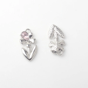 Detailed front and back view of silver alloy flower charm with a pink pear-shaped crystal