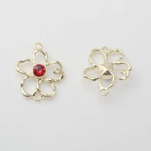 Detailansicht eines Goldblumen-Anhängers mit rotem Strass und doppelter Aufhängung