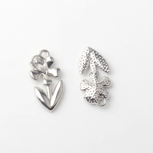 Detailed macro view of silver flower alloy charms showing front crystal and textured back