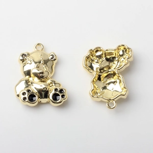 Vorder- und Rückansicht des goldenen Teddybär-Anhängers mit schwarzen Emaille-Pfoten