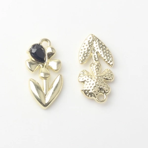 Detail of flower-shaped golden alloy pendant showing front stone and textured back view