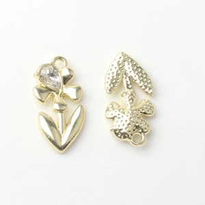 Macro detail of gold flower charm showing teardrop zircon and textured back side