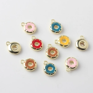 Flat lay of colorful enamel donut charms with golden hooks for DIY jewelry making