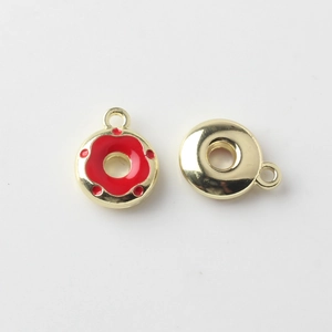 Macro shot of mini alloy donut pendants with red enamel and gold plating for DIY jewelry