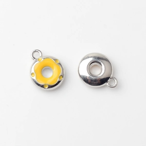 Macro detail of silver alloy donut charms with bright yellow enamel for DIY jewelry making
