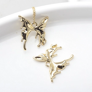 Molten style gold butterfly pendant necklace with fluid metal design on white ceramic