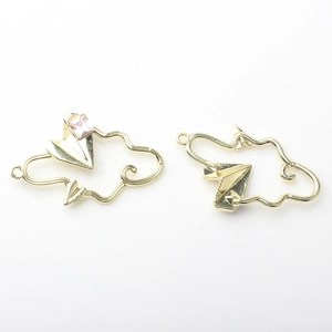 Close-up of gold hollow cloud and paper plane charms with a pink gemstone