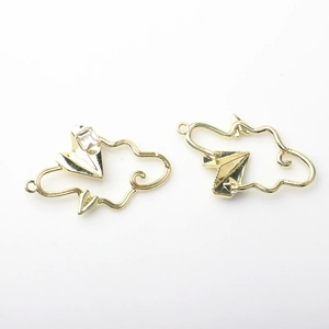 Detailed view of gold alloy cloud and paper airplane pendants with inlaid cubic zirconia
