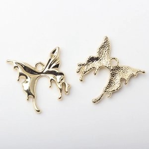Detail view of alloy butterfly pendants in polished gold and hammered texture finishes