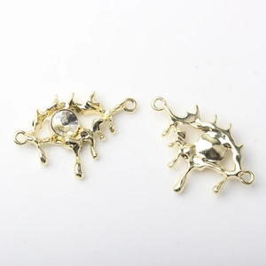 Macro view of gold melting eye charms with sparkling zircon for DIY jewelry making