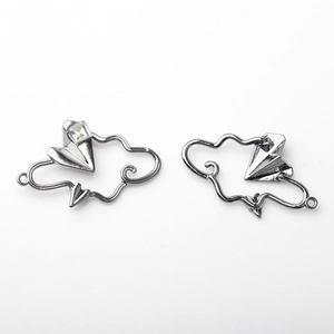 Detailed close-up of alloy cloud and paper plane jewelry charms with zircon inlay