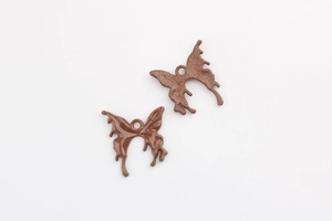 Detailed view of chocolate brown lava butterfly pendants in drip oil alloy with top ring