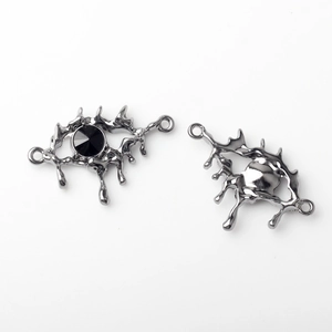 Detail of alloy eye pendant charms with black faceted stone in fluid lava style
