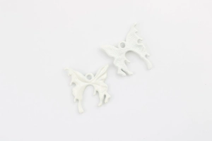 Detailed macro view of white butterfly alloy charms showing front and back texture