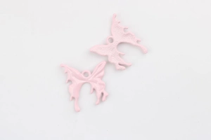 Detailed view of pink fluid-style butterfly charms with alloy texture and hanging holes