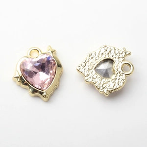 Macro detail of heart pendant with pink gemstone and gold alloy textured back side