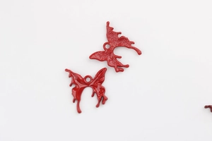Detailed macro view showing front and back of red butterfly pendants with alloy texture