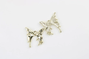Detail of gold butterfly charms with polished and hammered textures for DIY jewelry making