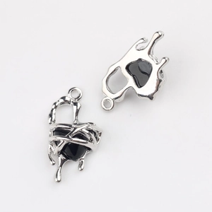 Dettaglio macro di ciondoli a cuore argento fluido con intarsio nero per gioielli fai da te