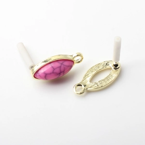 Detail of pink oval stone pendant with gold alloy frame and needle for DIY earrings