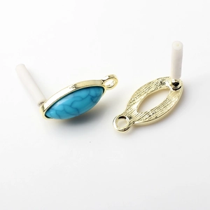 Macro shot of gold oval bezel link with turquoise stone inlay for DIY earring making