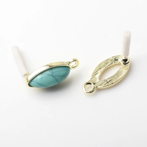 Detailed view of turquoise stones set in golden oval metal frames for DIY earring making