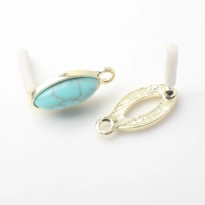 Macro detail of marquise turquoise charms with golden alloy frames for DIY earrings