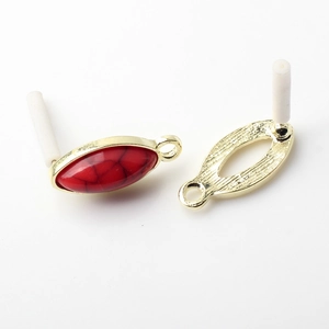 Detailed view of red marquise stone pendants with ornate golden metal backing for DIY