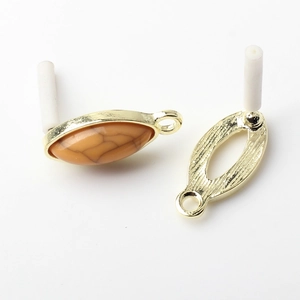 Detail of vintage marquise-shaped golden metal frame with brown marble resin inlay for DIY jewelry