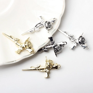 Macro detail of alloy rose cross charms in silver and gold finishes for DIY jewelry