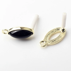Detailed macro view of vintage oval alloy earring connectors with black onyx stones