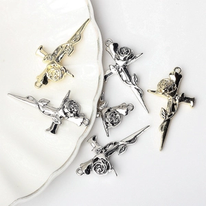 Macro detail of gothic rose pendants in gold and silver plating on a white plate