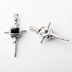 Macro detail of alloy cross pendants with hammered texture and black center stones