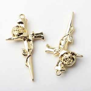 Macro detail of gold-plated rose cross alloy charms for DIY necklaces and earrings