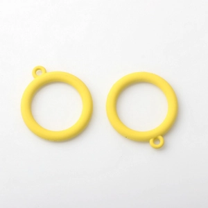 Macro shot of two bright yellow matte alloy hollow round charms for DIY jewelry making