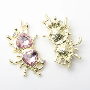 Detailansicht von Flüssigmetall-Herzanhängern mit rosa Kristallen und Diamanten