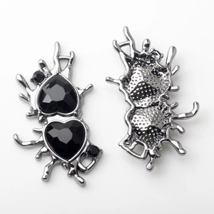 Detail von Gothic Herz-Anhängern aus flüssigem Metall mit schwarzen Kristallen und Textur