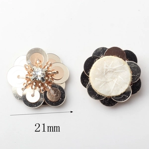 Macro-opname van handgemaakte pailletten bloemen van 21mm met goudkleurige kralen en kristallen