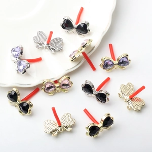 Minimalist alloy bow earring findings with heart-shaped crystals in gold and silver settings