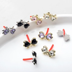 Macro detail of alloy butterfly bow charms with heart-shaped crystals for DIY earrings