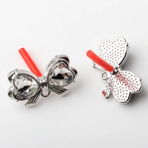 Detail of silver alloy bow charm with heart crystals for DIY earring and jewelry making